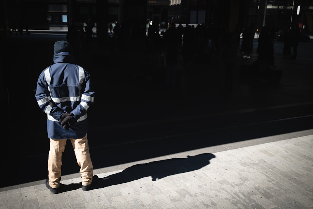 a man standing on a sidewalk in front of a building