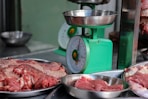 meat is being weighed on a scale in a kitchen