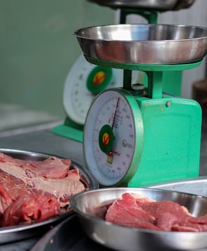 meat is being weighed on a scale in a kitchen