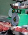 meat is being weighed on a scale in a kitchen