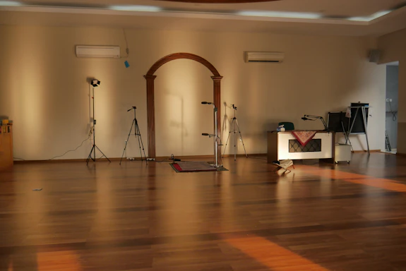 A cozy rehearsal room with warm lighting and acting props scattered around.