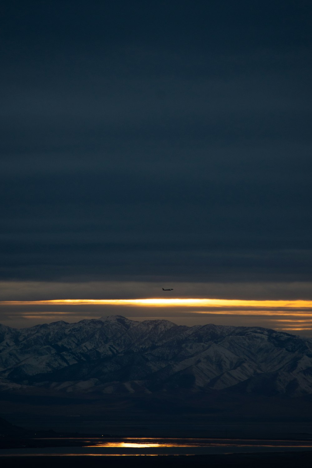 Un avión sobrevolando una cadena montañosa por la noche