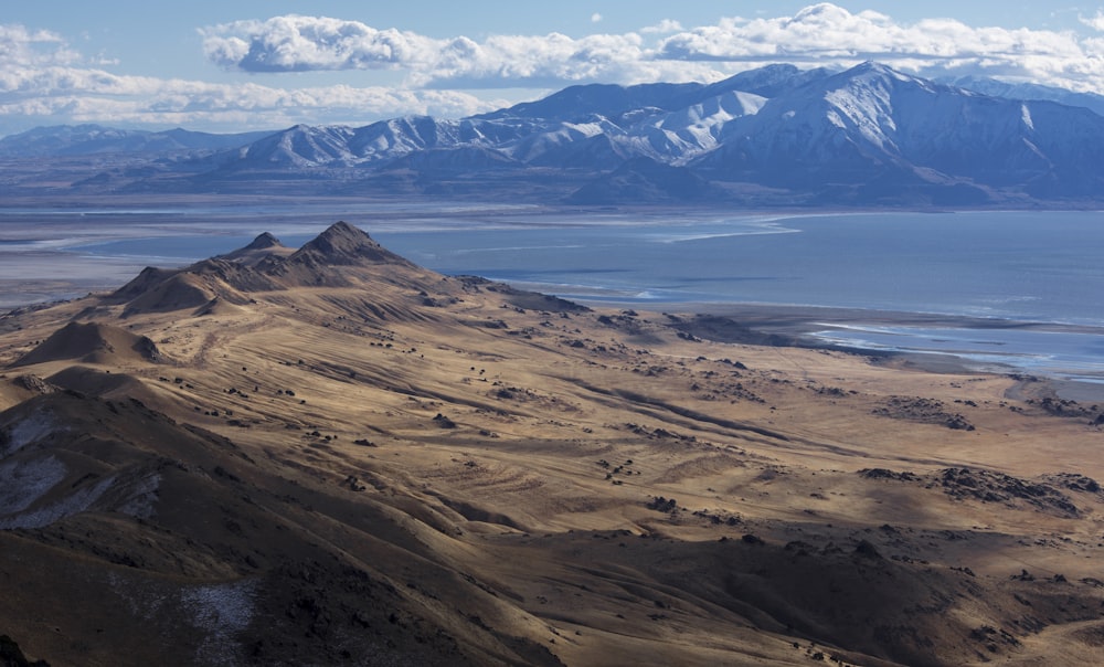 a mountain range with a body of water and mountains in the background