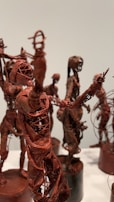 Intricately crafted sculptures made of wire and possibly clay or resin. The sculptures depict abstract human figures in various poses, with visible details resembling muscles and ligaments. The overall appearance is artistic and thought-provoking.