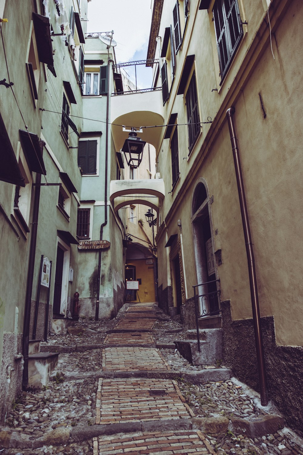 a narrow alley way with a clock on the wall