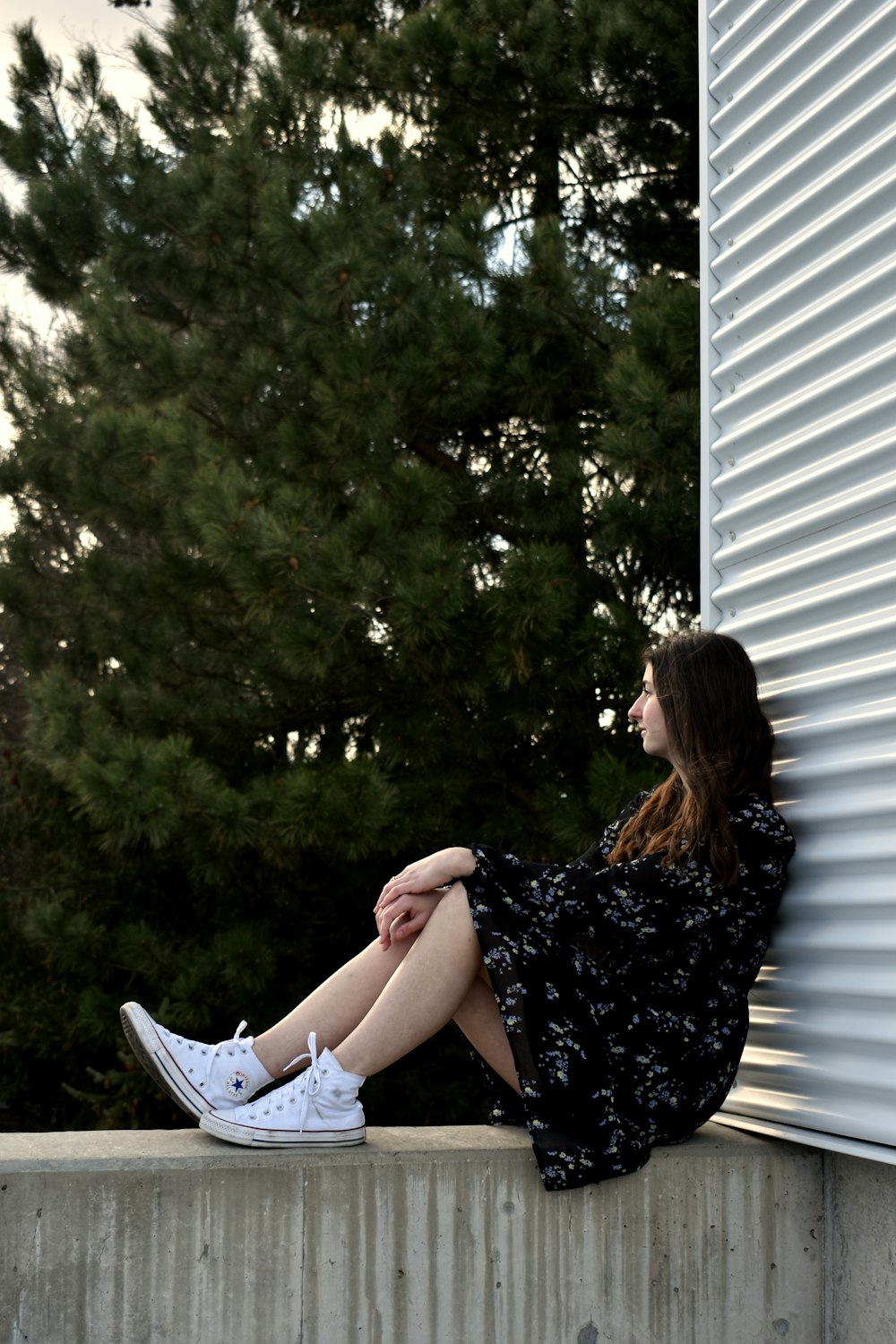 a woman is sitting on a concrete ledge