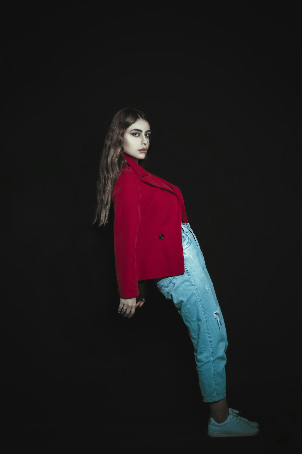 a woman in a red jacket and jeans