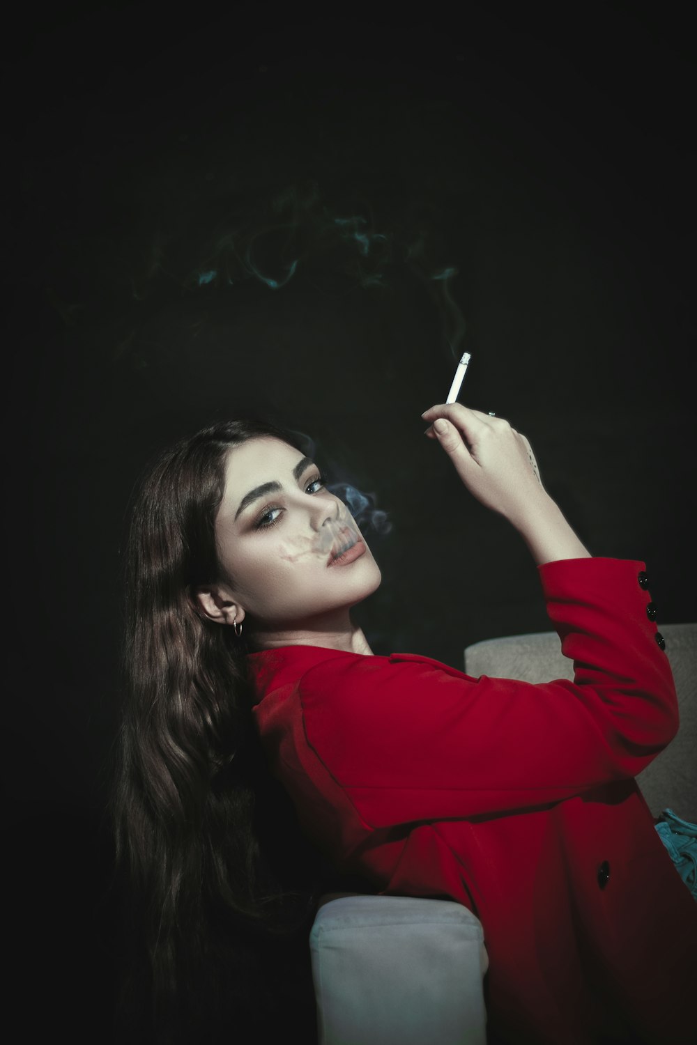 a woman in a red shirt smoking a cigarette