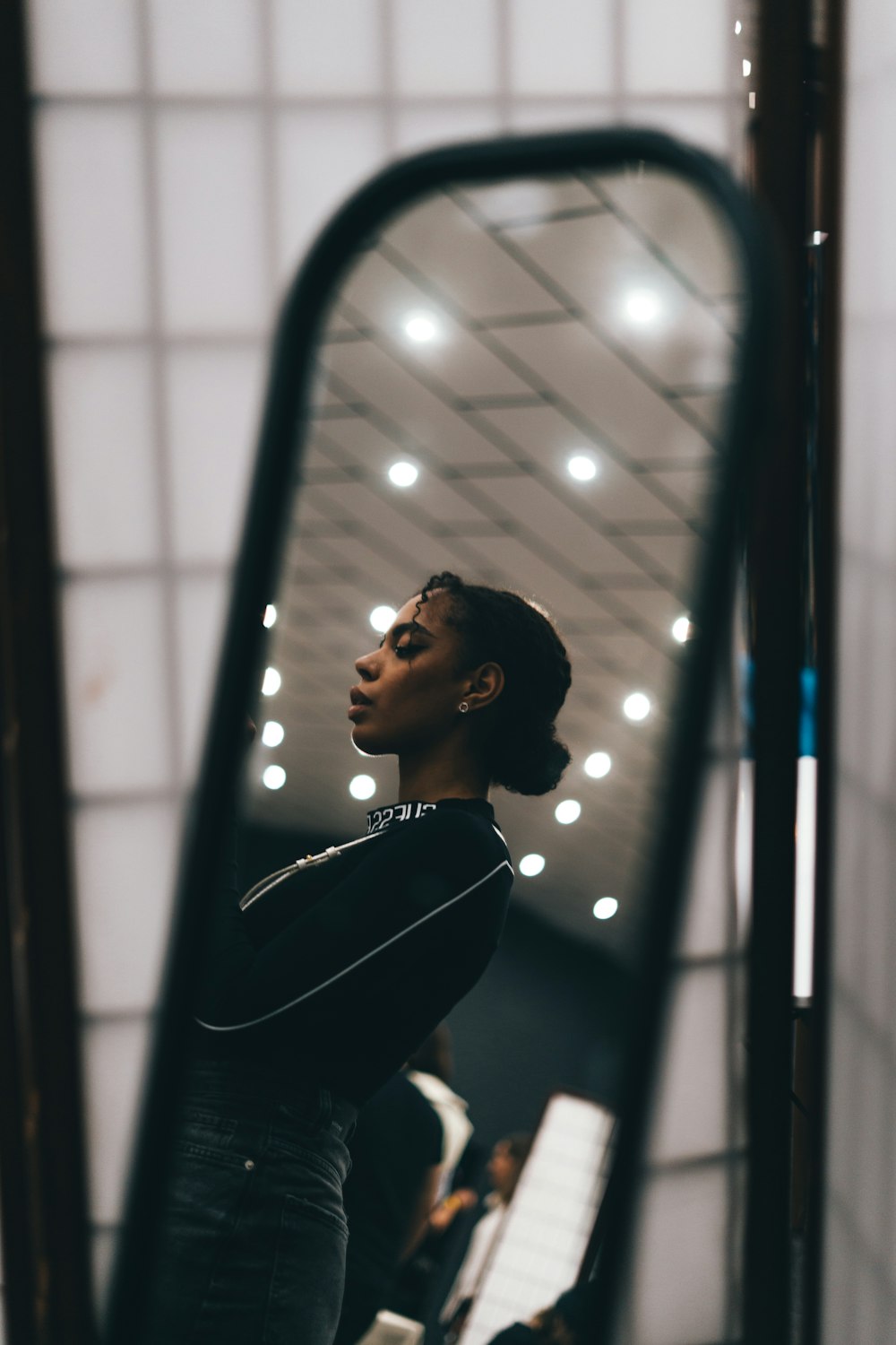 Une femme debout devant un miroir