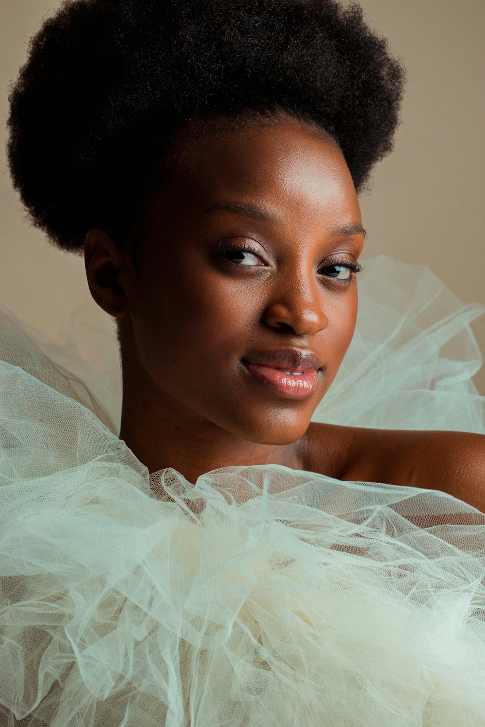 a woman in a white dress with a big afro