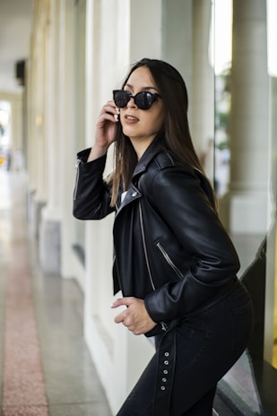 A stylish model wearing a leather jacket in an urban setting, exuding confidence and elegance.