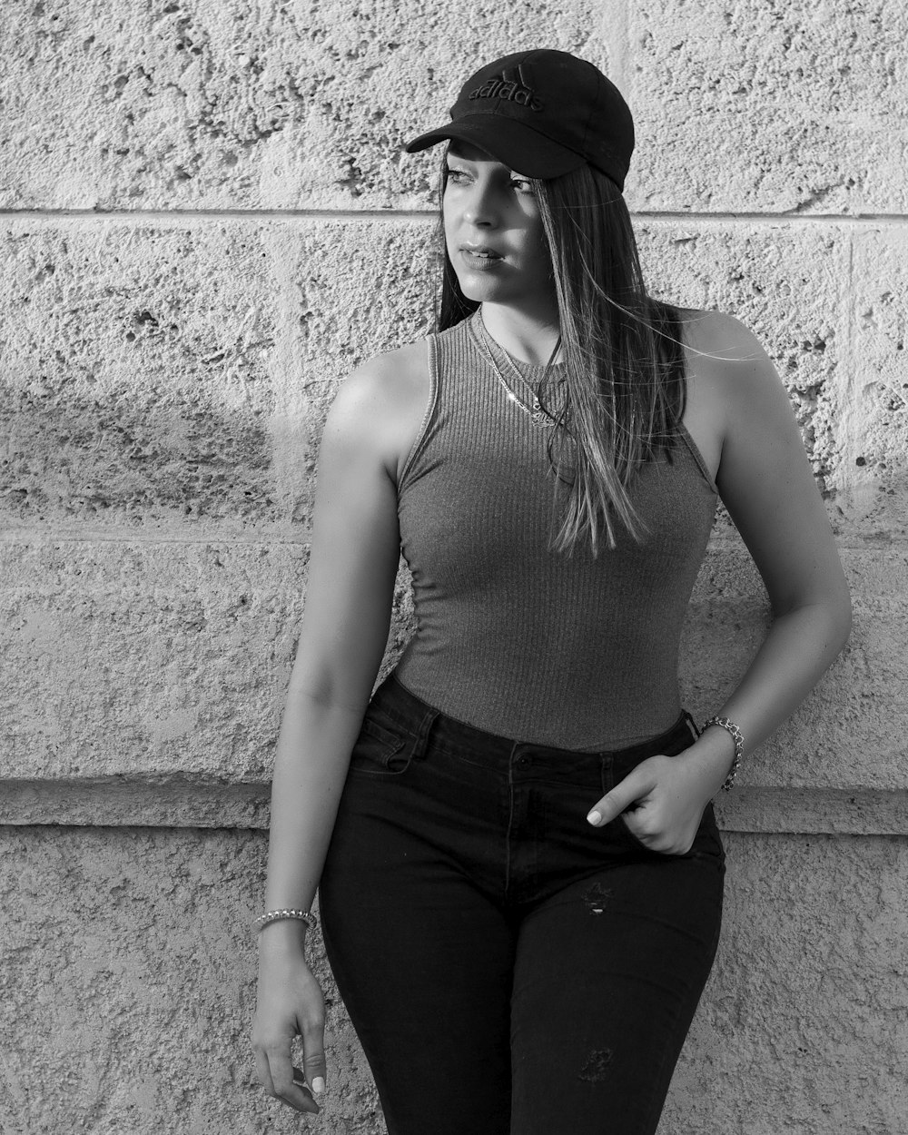 a black and white photo of a woman leaning against a wall