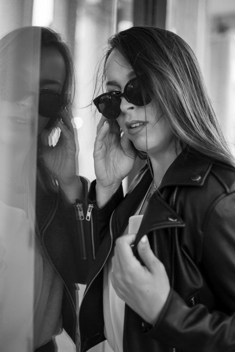 a woman talking on a cell phone in front of a mirror