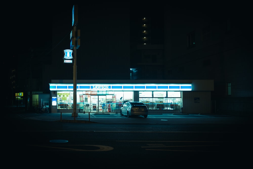 um carro estacionado em frente a um posto de gasolina à noite