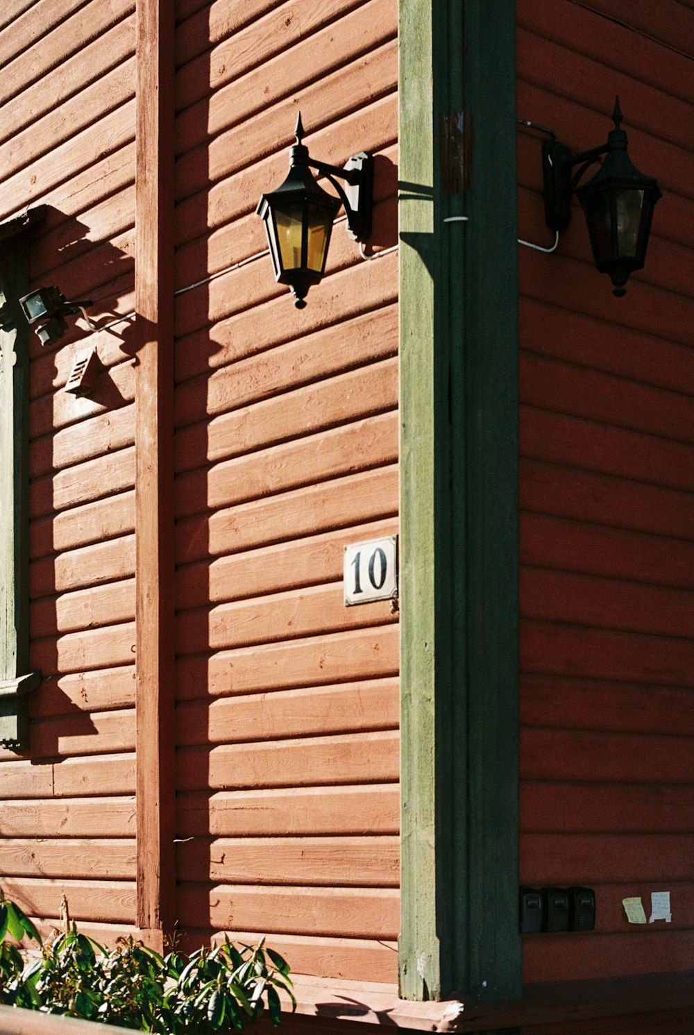 a red building with a green door and a street light