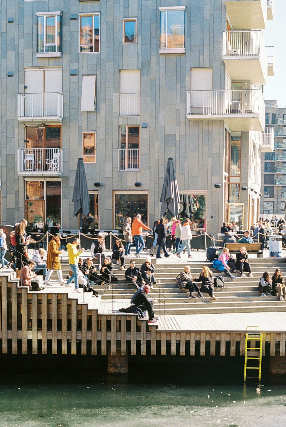 a group of people sitting and standing on a pier