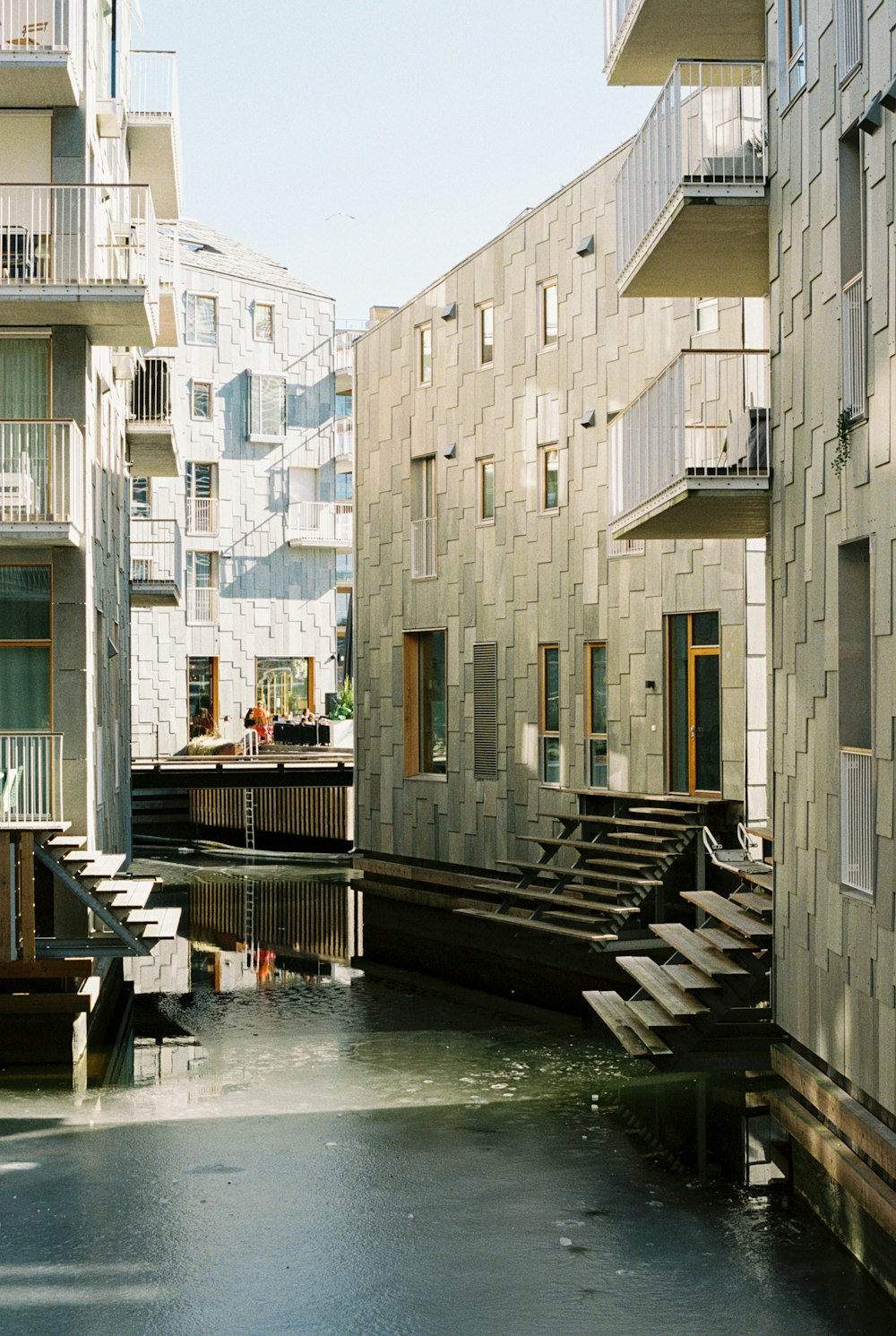 a building with a bunch of windows next to a body of water