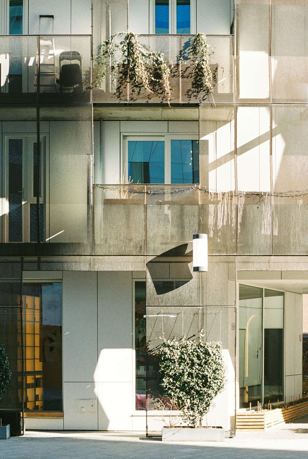 a tall building with balconies and plants on the balconies