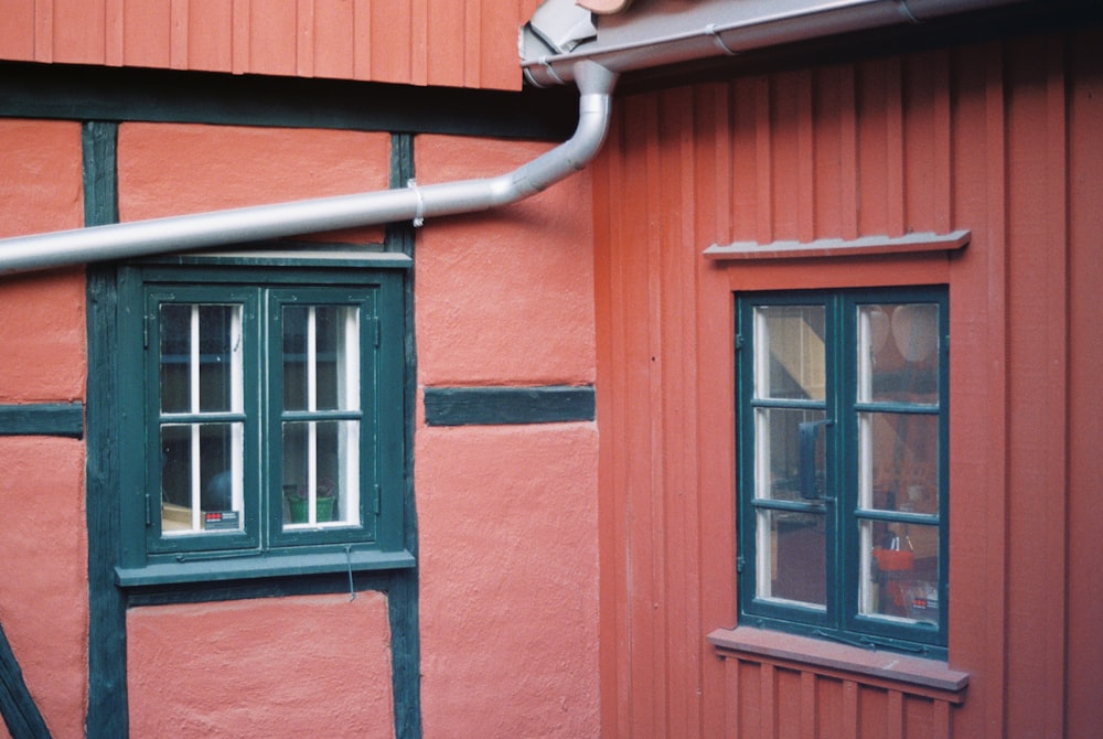 a red building with a pipe running from the side of it