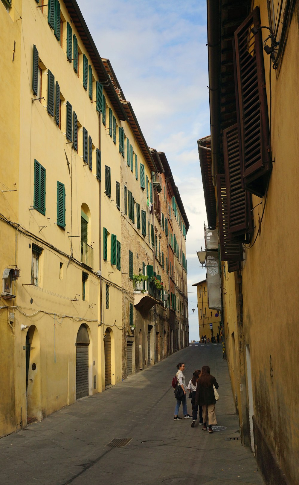 Un gruppo di persone che camminano lungo una strada accanto a edifici alti