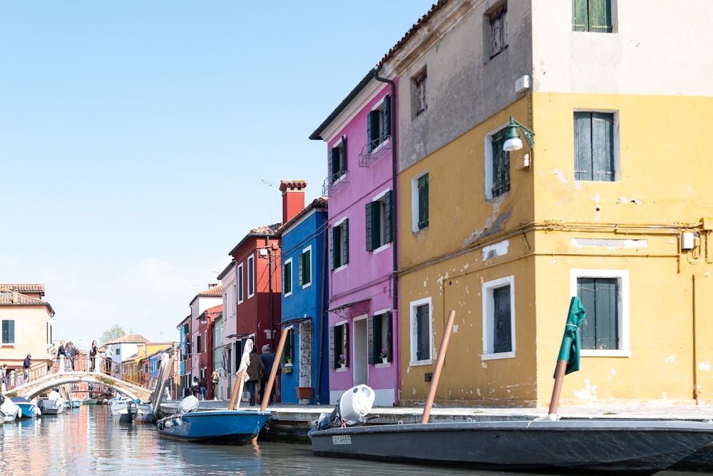 a row of houses along a canal with a boat in the water