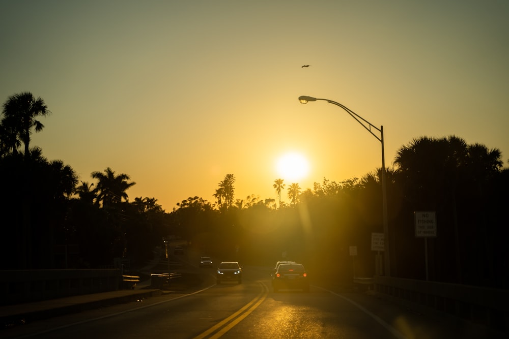 the sun is setting over a city street