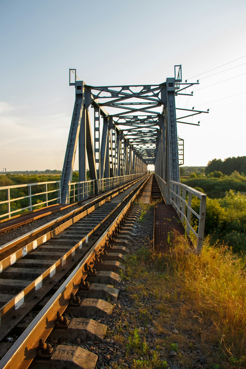 a train track going across a bridge over a field