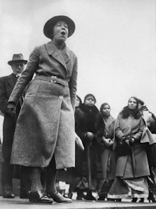 A close-up of a woman speaking passionately at an International Women's Day event.