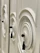 Close-up of a hand gently holding a sleek tectum handle on a white cabinet door