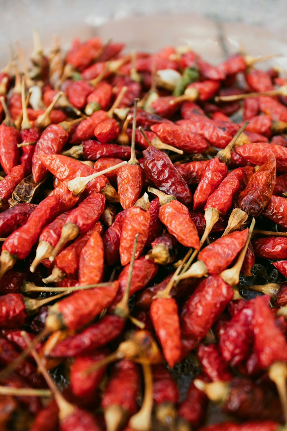 a pile of dried red peppers sitting on top of a table