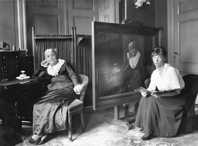 An elegant older woman receiving personalized travel arrangements from a concierge in a sophisticated office.