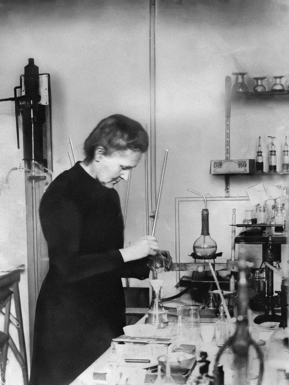 Una mujer trabajando en un laboratorio con muchas botellas