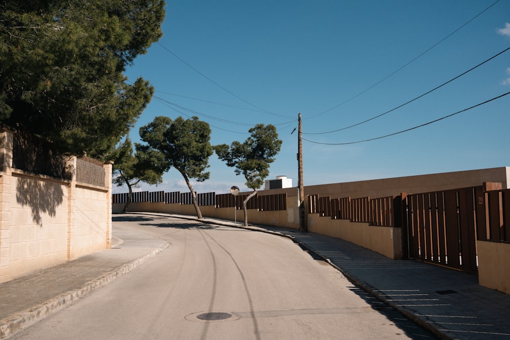 a street lined with trees and a fence