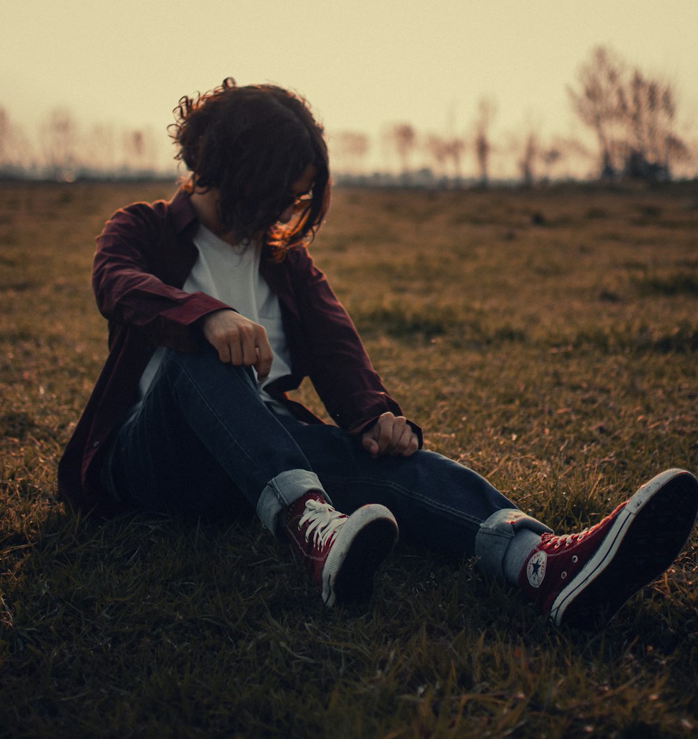 a person sitting on the ground in a field