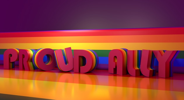 Large 3D letters spelling 'Proud Ally' are presented against a vivid rainbow background. The rainbow pattern extends across the floor and backdrop, casting reflections and enhancing the colorful atmosphere.