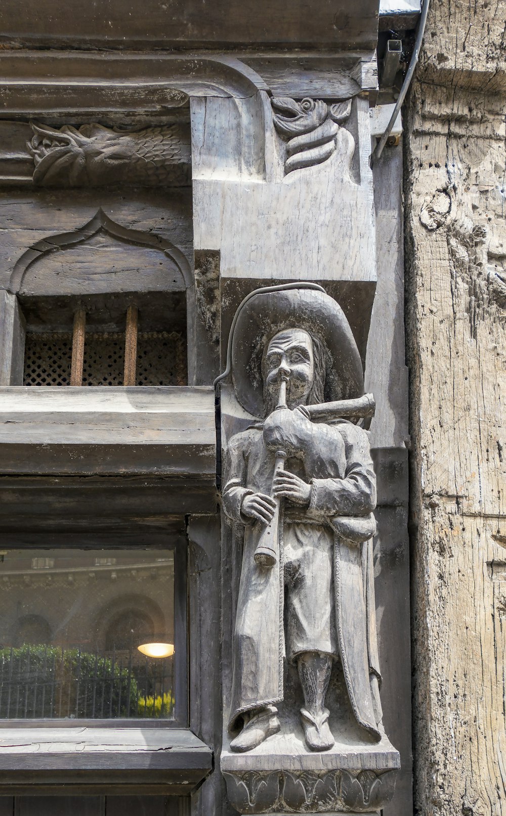 a statue of a man holding a bird on the side of a building