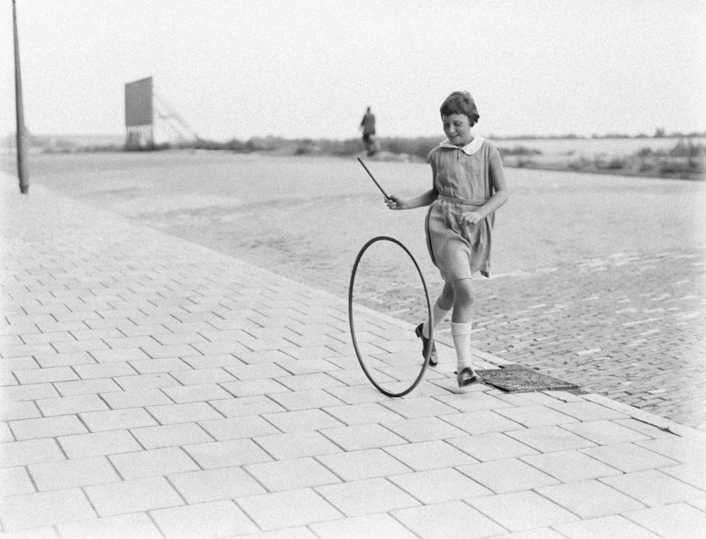 a young girl is holding a large hoop