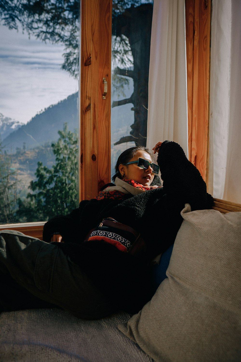 a woman sitting on a couch next to a window