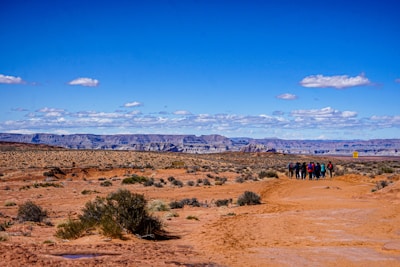 A group of diverse individuals engaging in a guided tour in a desert landscape.