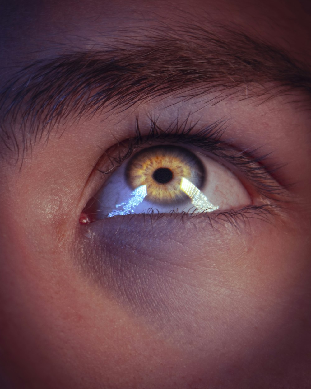 a man's eye with the reflection of an eyeball in it