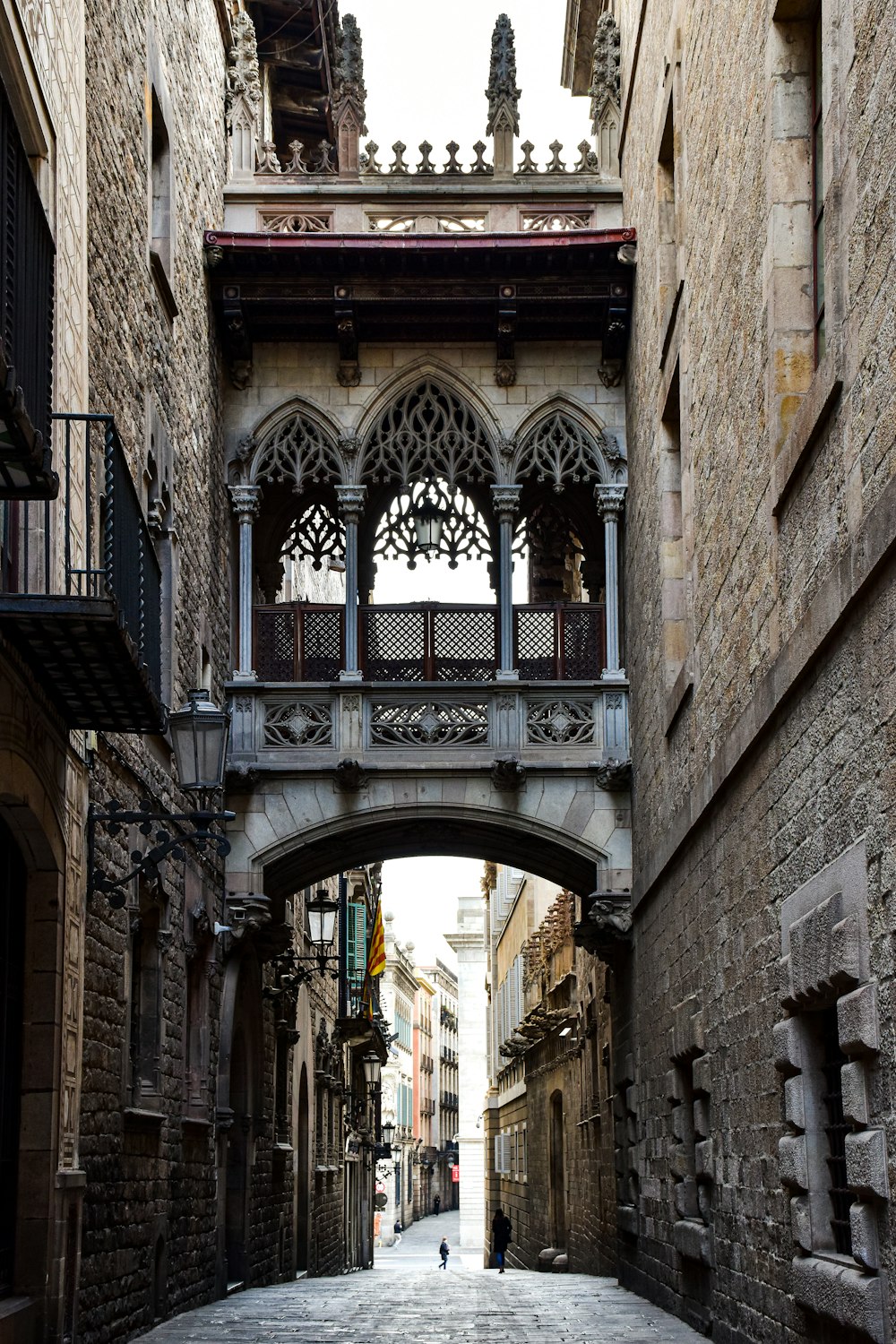 a person walking down a street under a bridge