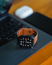 an apple watch sitting on top of a laptop computer
