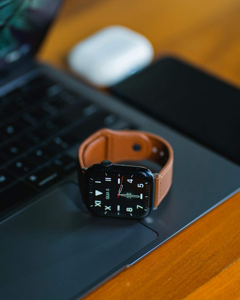 an apple watch sitting on top of a laptop computer