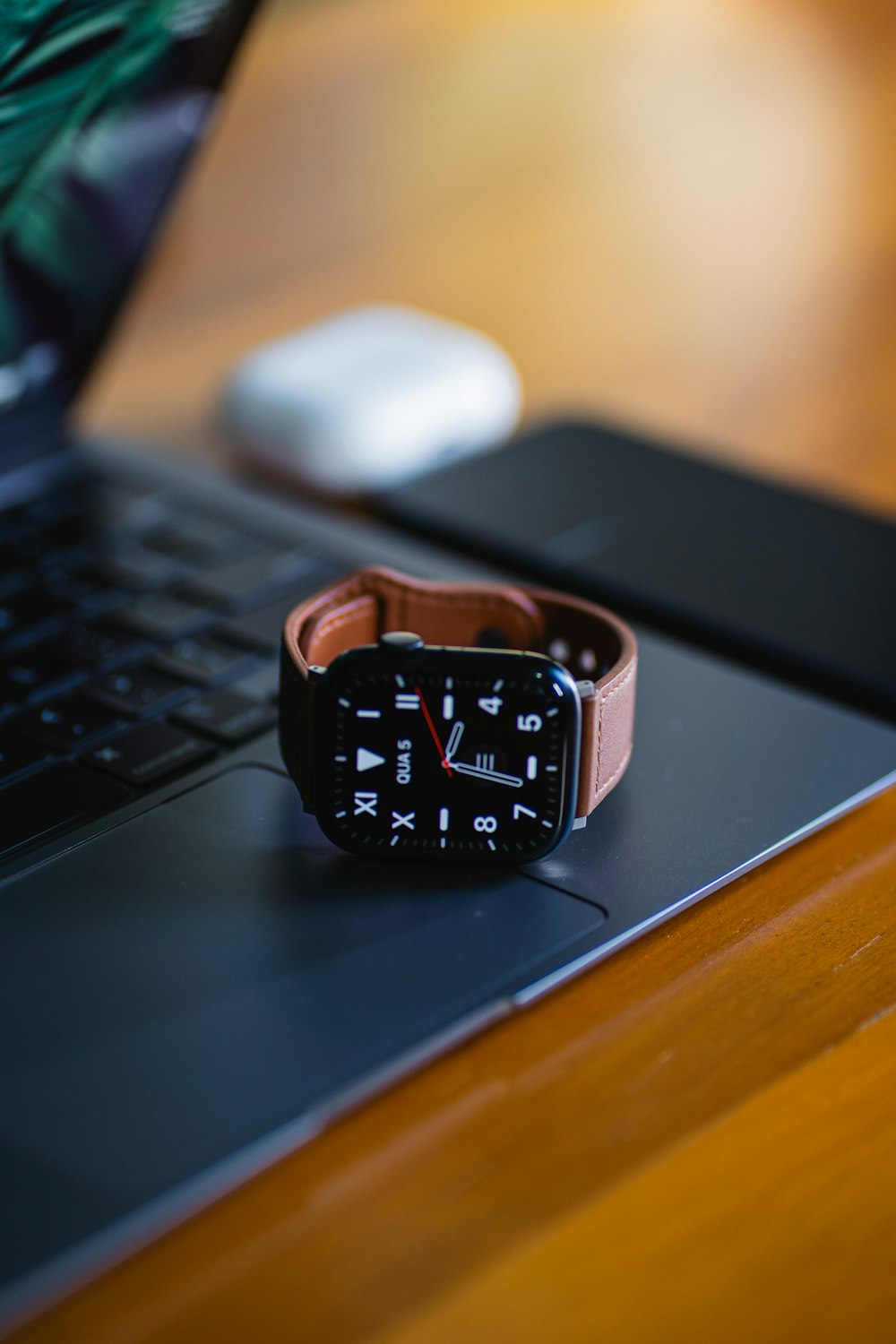 a watch sitting on top of a laptop computer