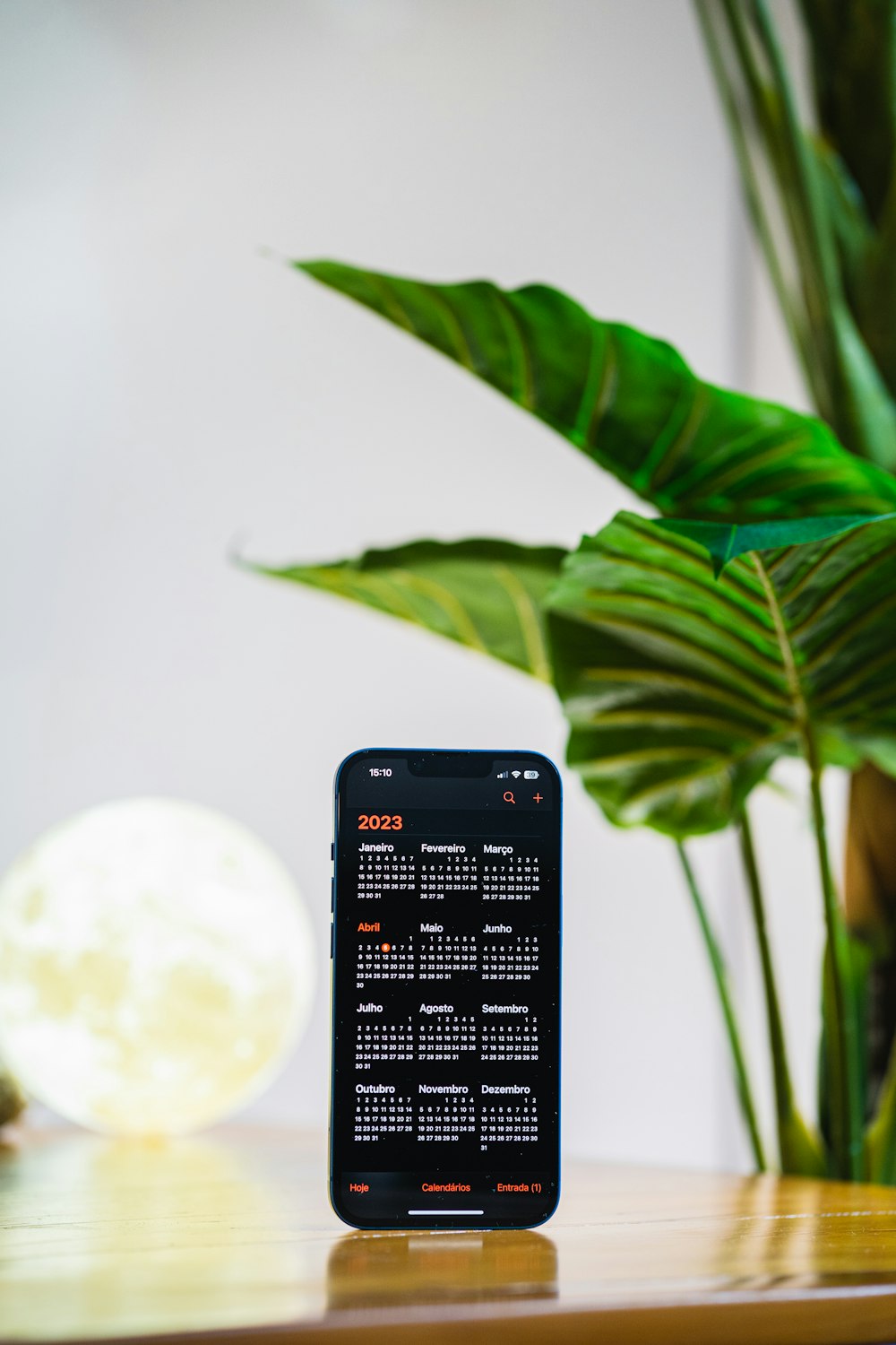 a cell phone sitting on a table next to a plant