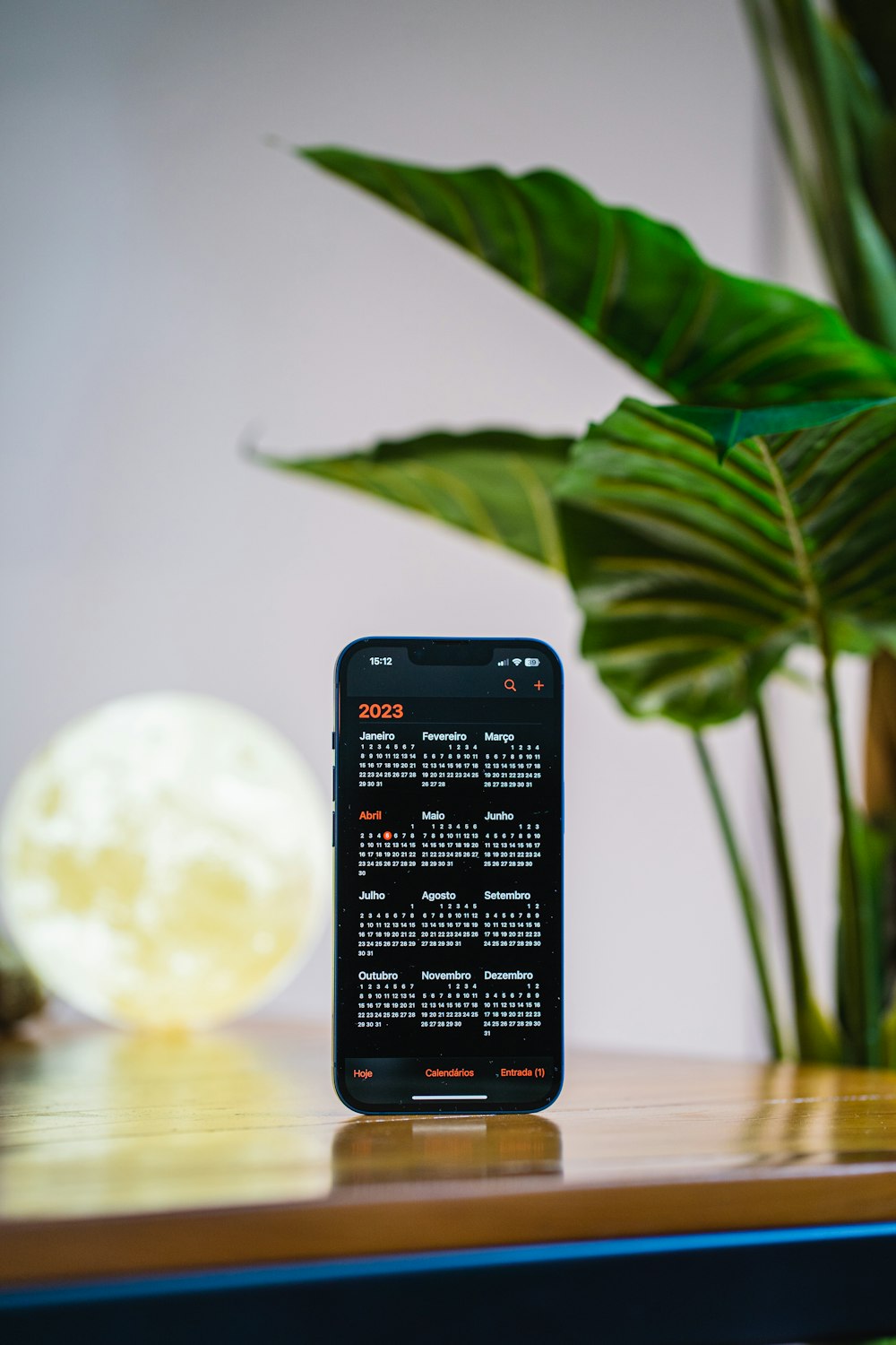 a cell phone sitting on a table next to a plant