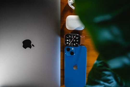 an apple laptop computer sitting on top of a wooden table