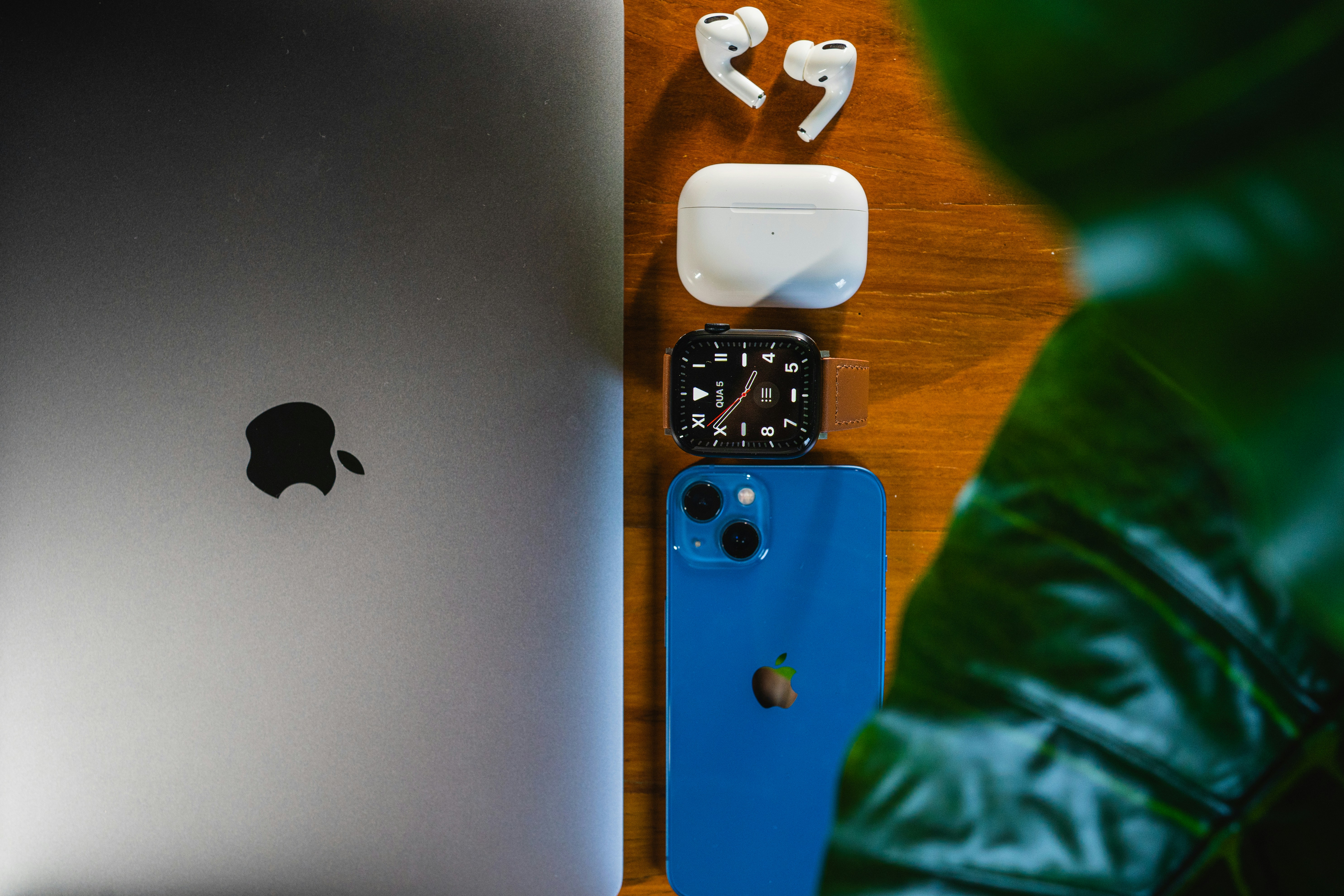 an apple watch, earbuds, and an ipod on a table