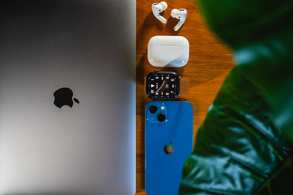 an apple watch, earbuds, and an ipod on a table