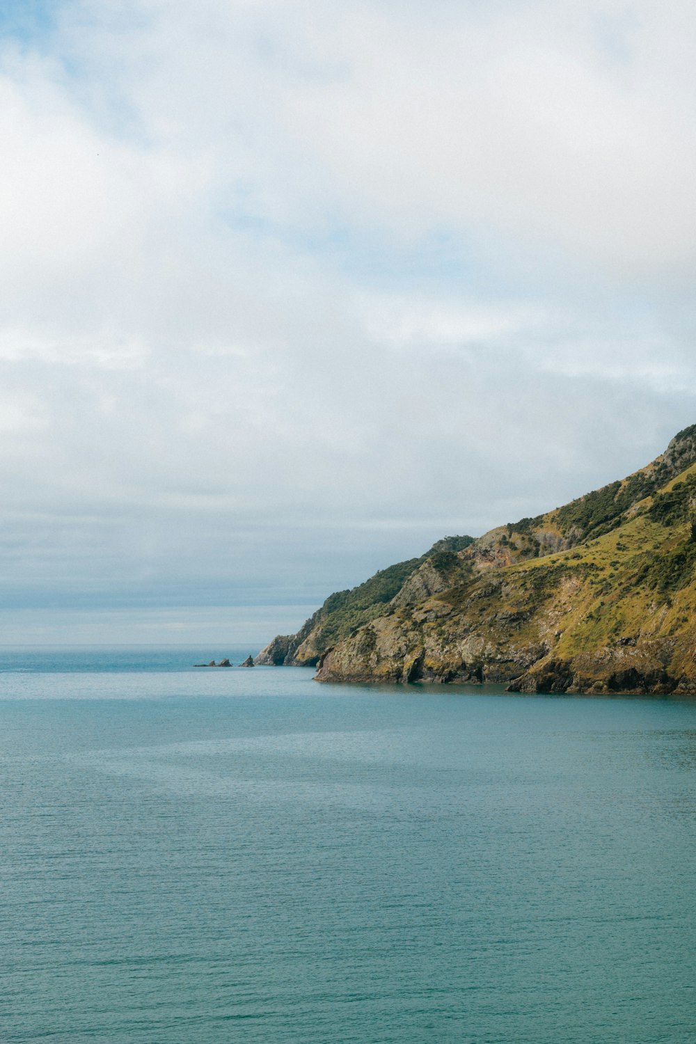 a large body of water with a mountain in the background